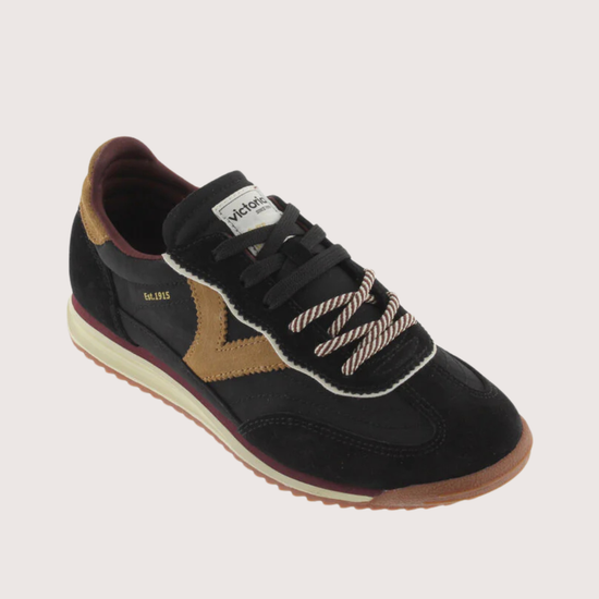 A black suede and mesh low-top sneaker with tan side panels, burgundy lining, and a cream midsole, shown from a side profile on a light gray background.