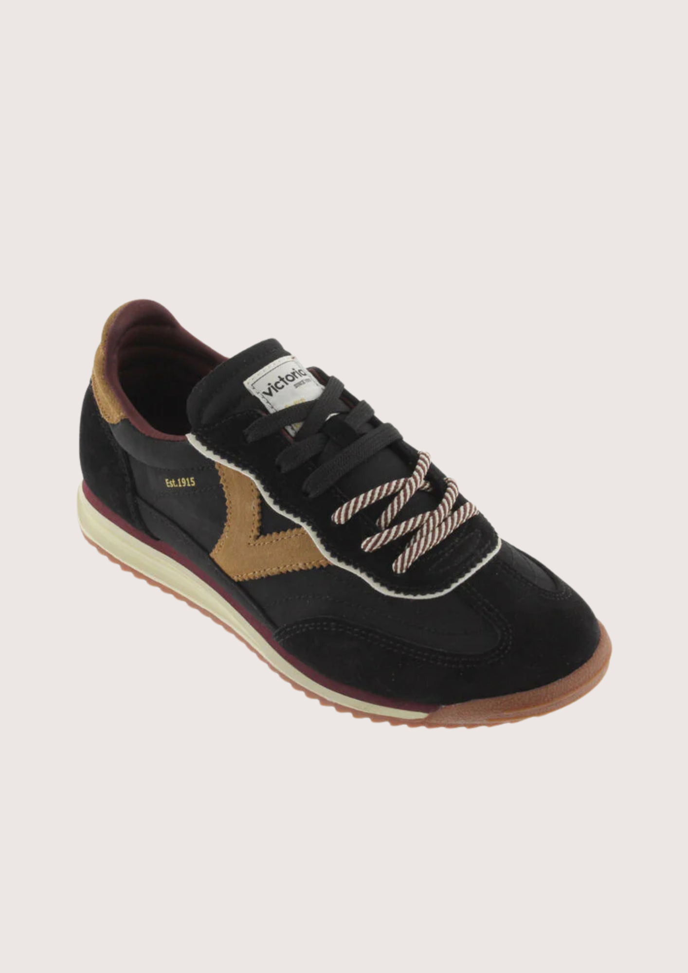 A black suede and mesh low-top sneaker with tan side panels, burgundy lining, and a cream midsole, shown from a side profile on a light gray background.