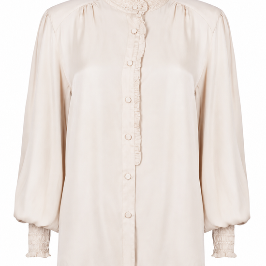 A cream-colored long-sleeve blouse with a high ruffled collar, button-down front, and textured ruffled cuffs, shown against a plain white background.