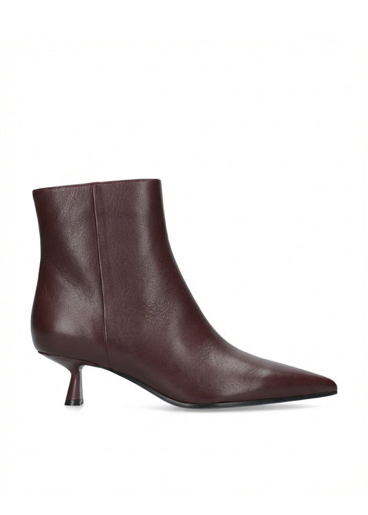 A single dark burgundy leather ankle boot with a pointed toe and a short kitten heel, shown from a side profile on a white background.