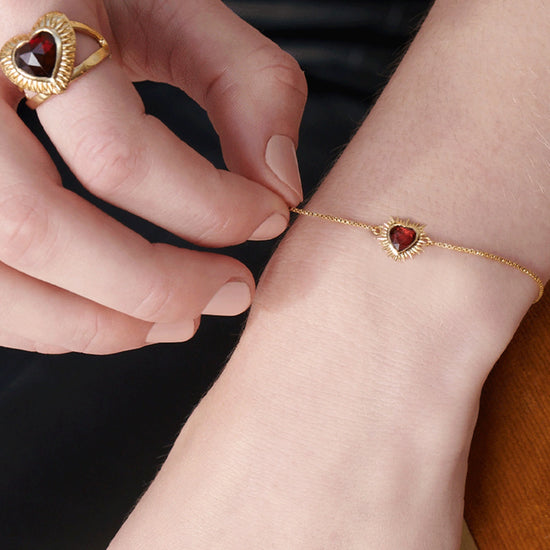 gold heart shaped adjustable ring  with red stone inside from rachel jackson model shot