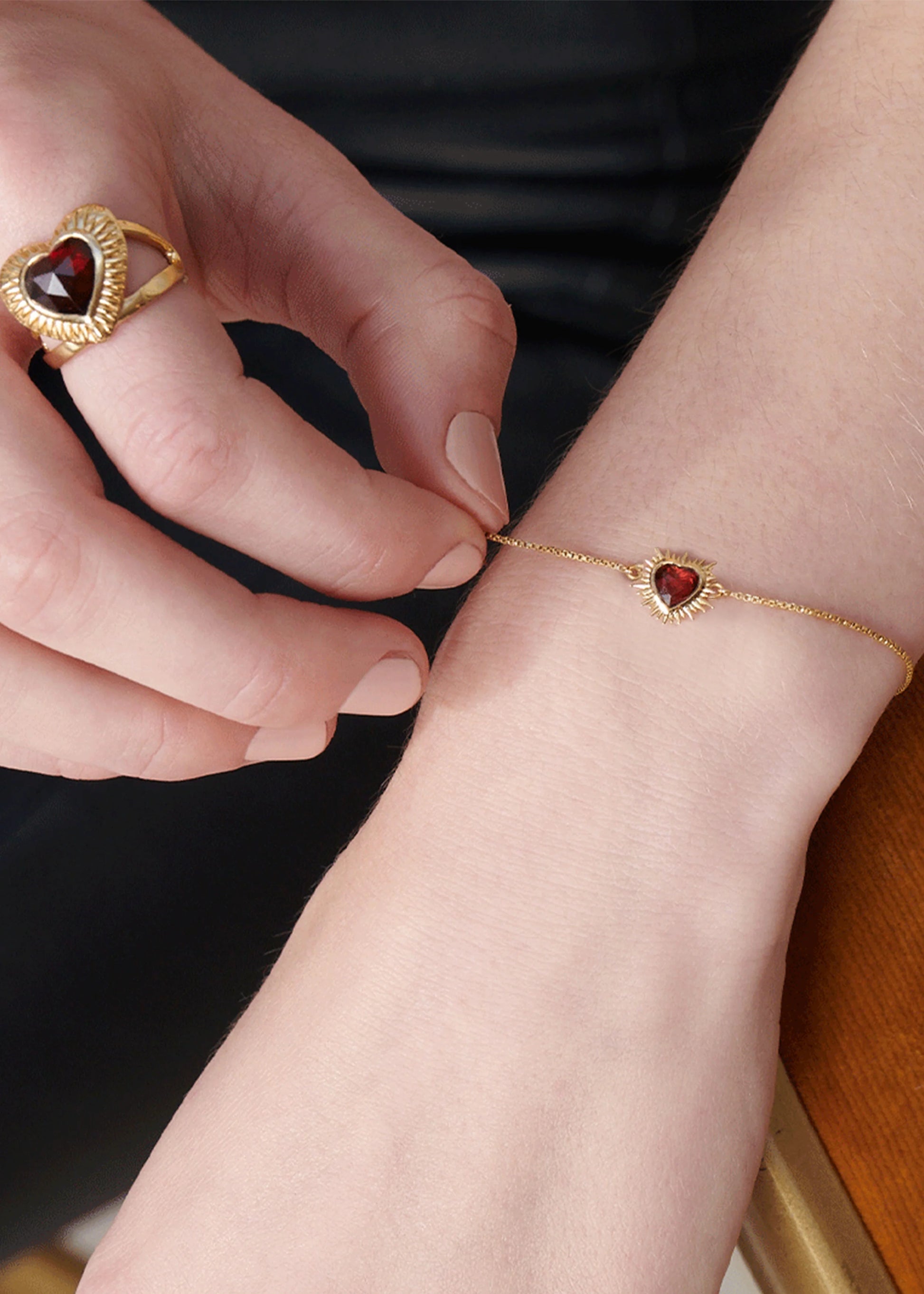 gold heart shaped adjustable ring  with red stone inside from rachel jackson model shot