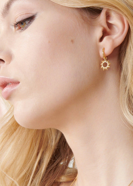 small gold huggie hoop earrings with spiky sunshine charms from rachel jackson model shot