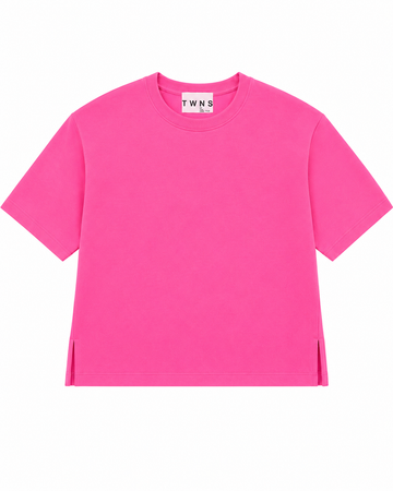 A bright pink short-sleeve crewneck t-shirt with side slits at the hem, displayed flat against a solid white background. The inner neck label shows the brand name 'TWN S'.