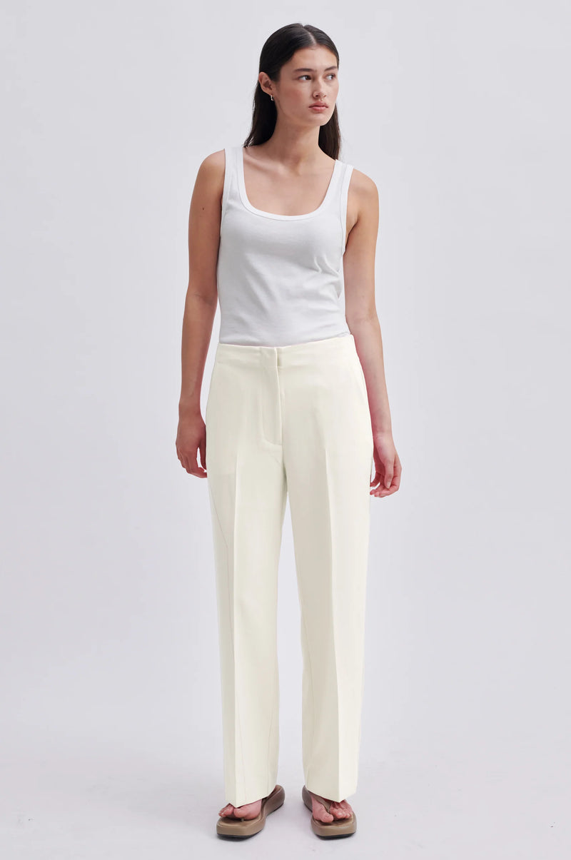 Cream tailored trousers with elasticated waistband at the back side pockets and straight legs