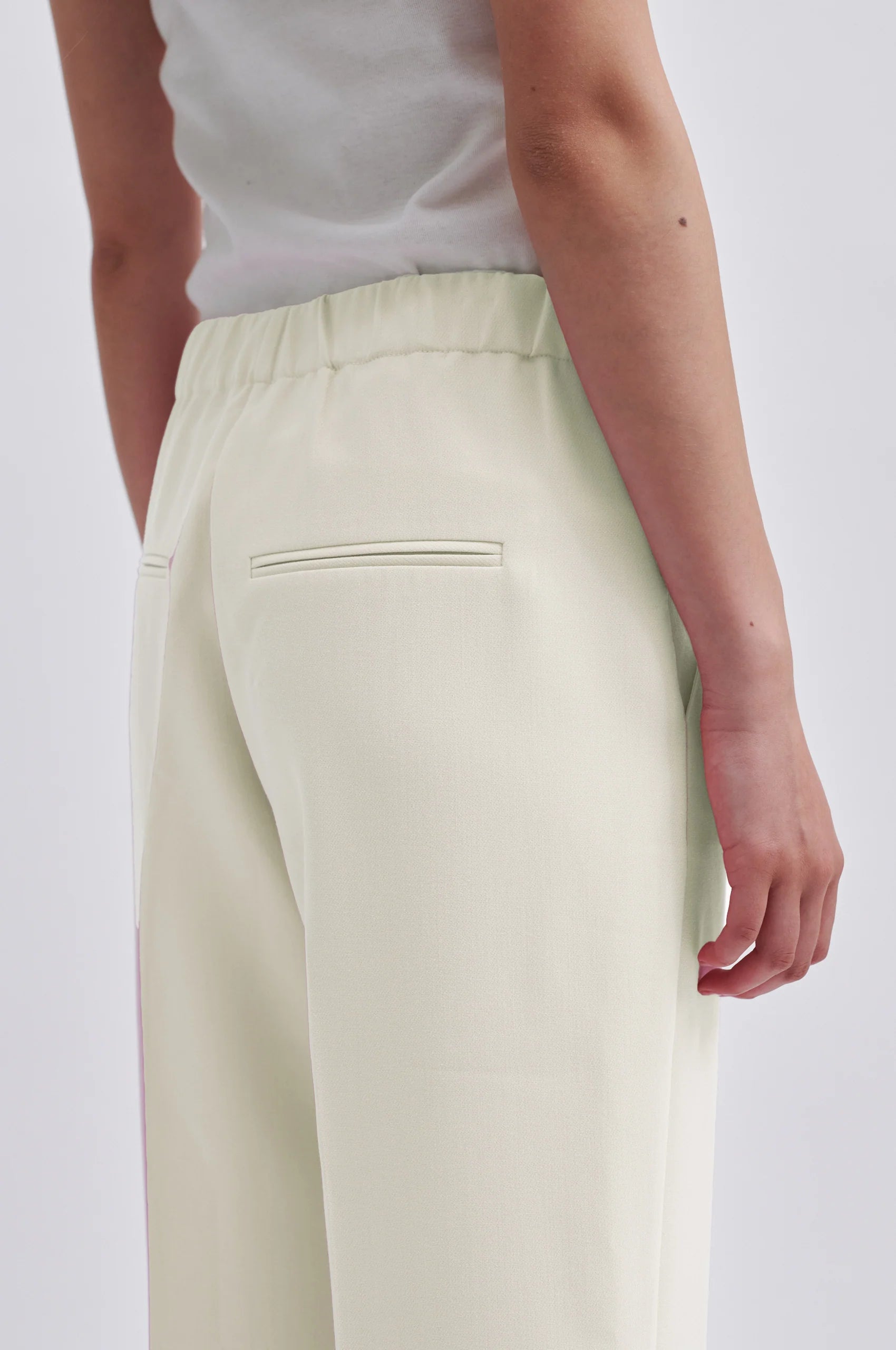 Cream tailored trousers with elasticated waistband at the back side pockets and straight legs