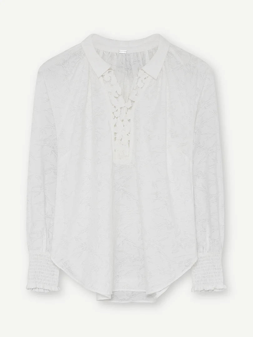 Flat lay of the white blouse with lace insert at the neck