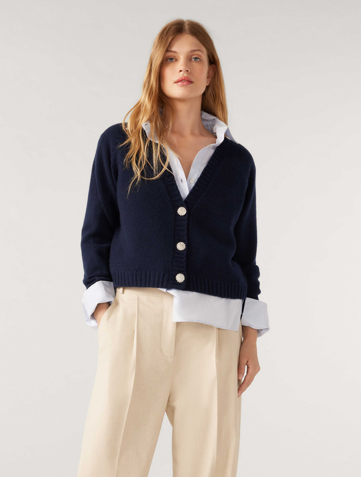 Navy V neck short cashmere cardigan with patch pockets and three bejewelled button fastening with raglan sleeves