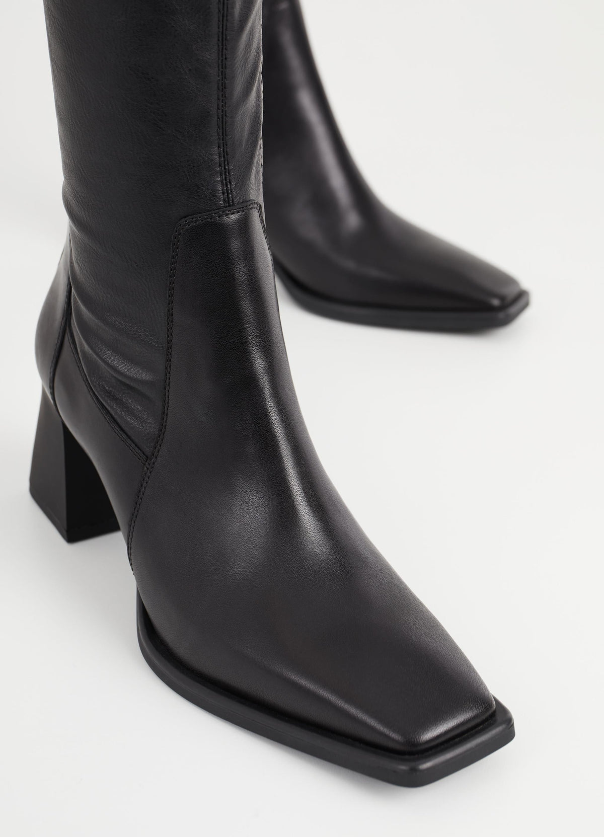 Mid-length inside zip black leather boot with flared block rubber heel and rounded square toe