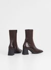 Mid-length inside zip brown leather boot with flared block rubber heel and rounded square toe