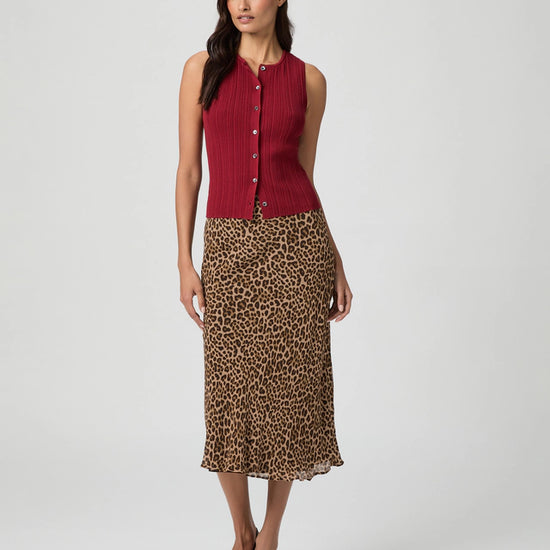 Woman wearing a red sleeveless top and leopard print skirt from Paige