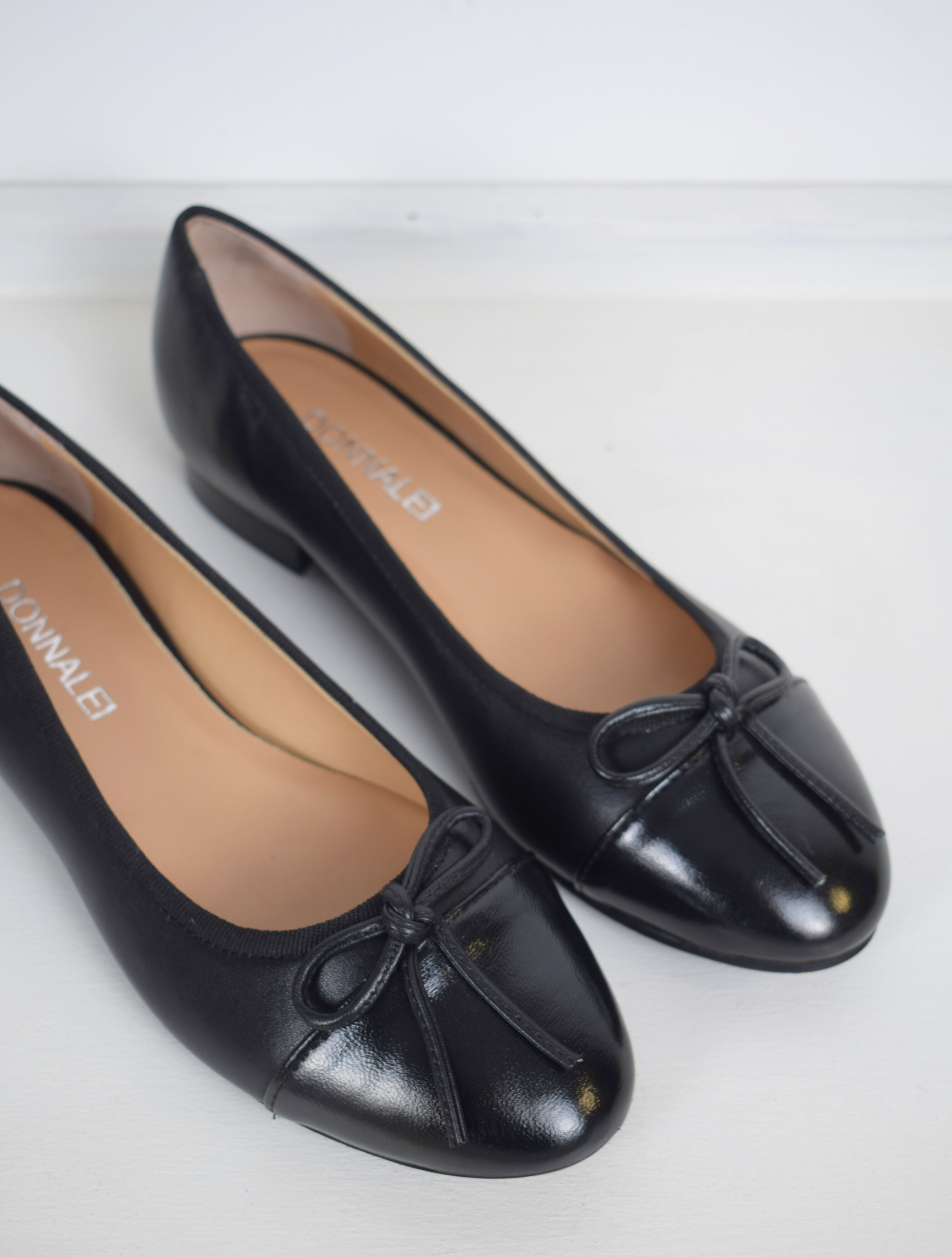 Black ballet pump with patent black toe and bow detail