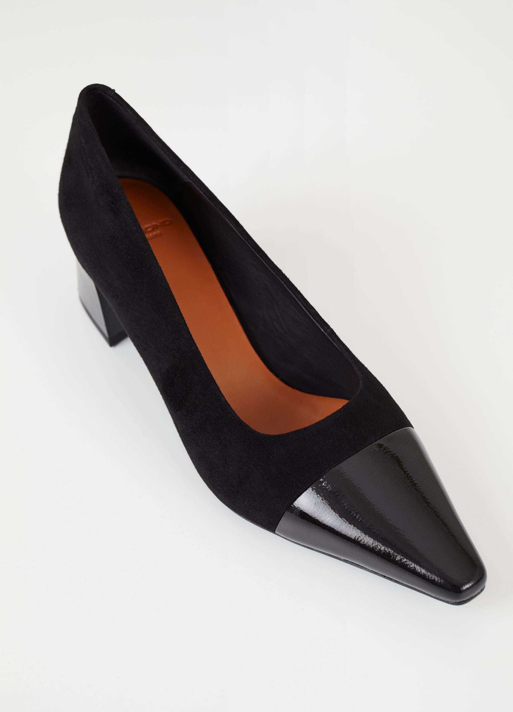 Black suede pumps with stacked black heel and pointed contrast black patent toe