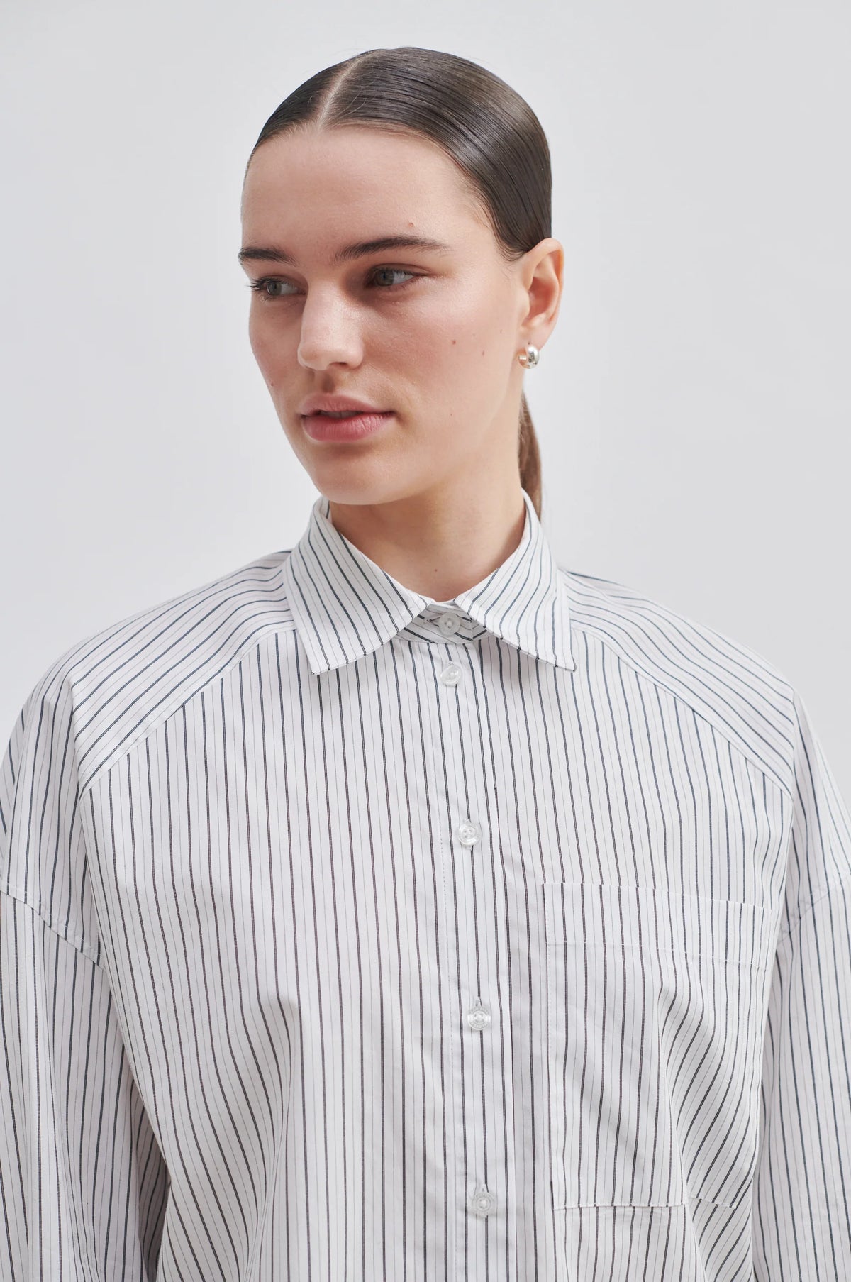 Oversized long sleeved striped shirt with classic collar patch pocket and curved hem