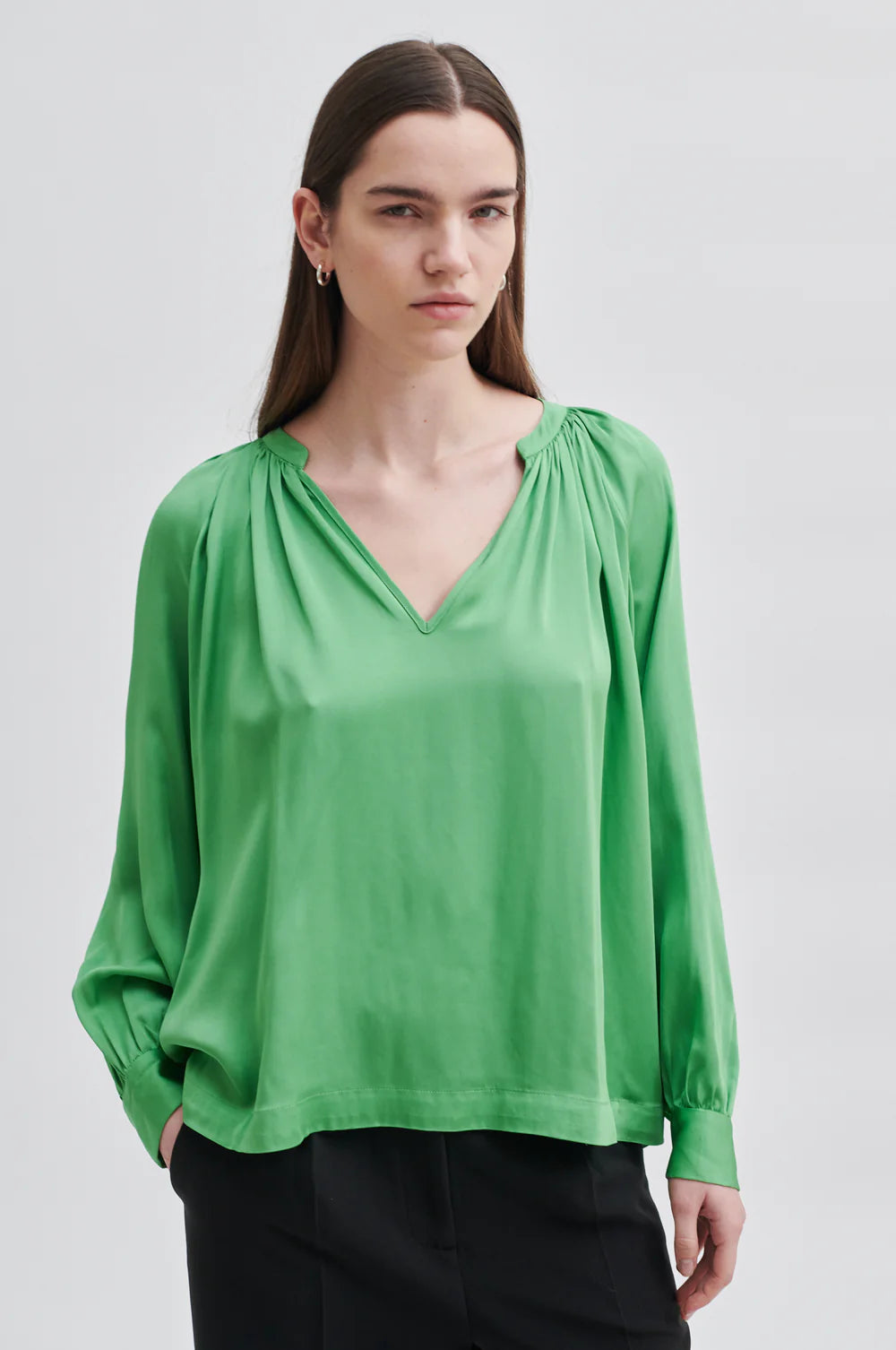 Green satin pull on top with notch neck raglan sleeves and double button cuff fastening