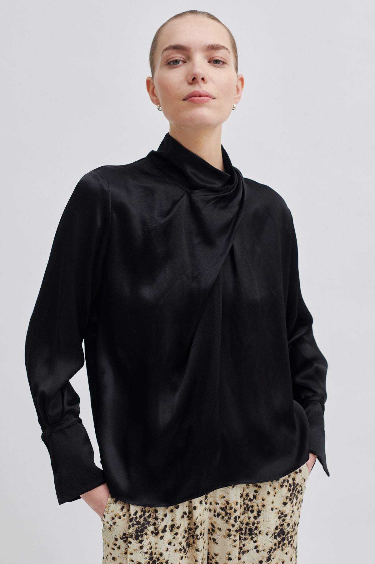 Black satin top with twisted neckline and long sleeves