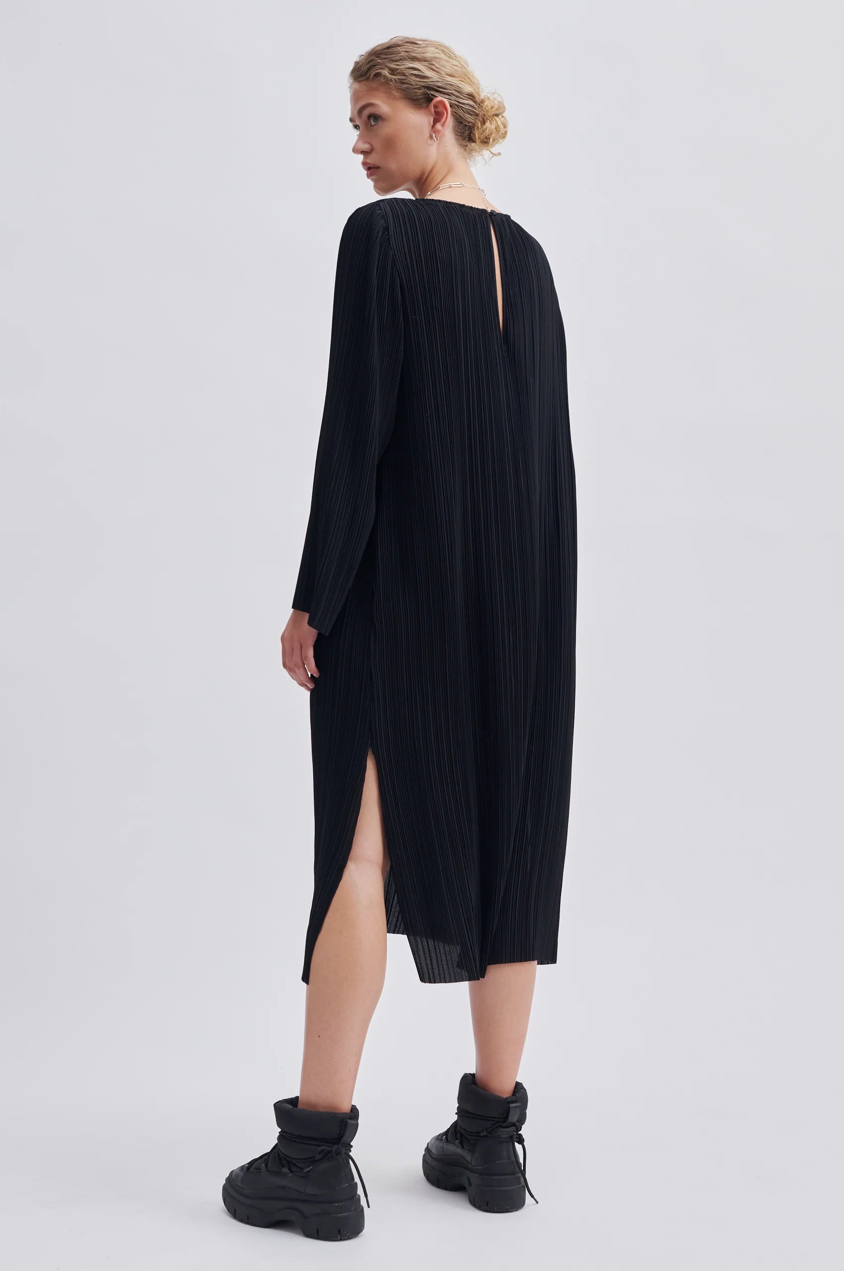 Black micro pleated round neck dress with long sleeves and side splits at the hem