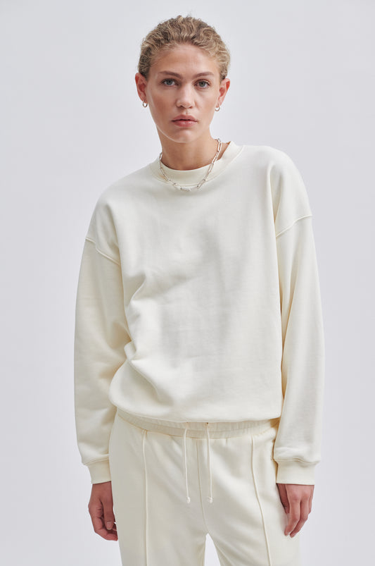 Cream coloured crew neck sweatshirt with ribbed cuffs and hem