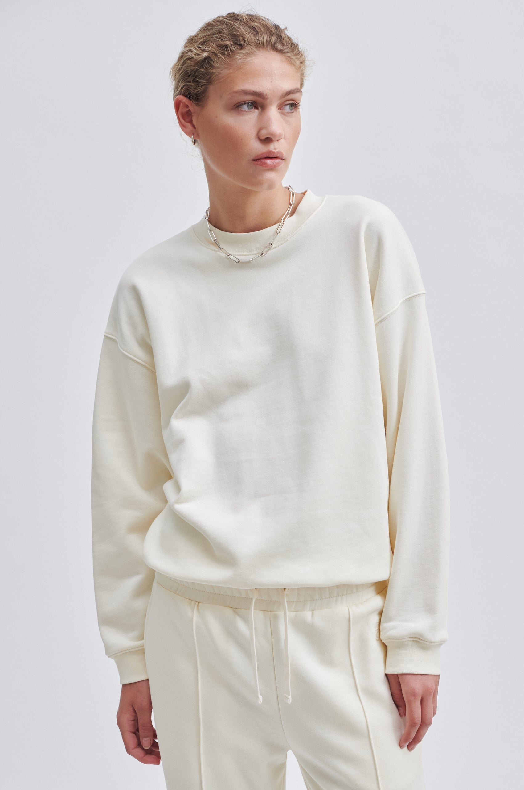 Cream coloured crew neck sweatshirt with ribbed cuffs and hem