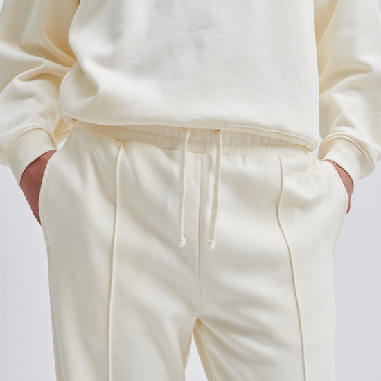 Straight leg cream joggers with side seam pockets and elasticated waistband with drawstring tie