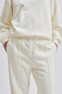 Straight leg cream joggers with side seam pockets and elasticated waistband with drawstring tie