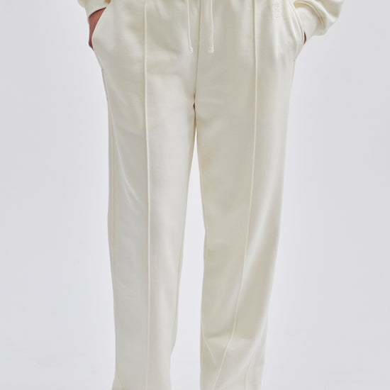 Straight leg cream joggers with side seam pockets and elasticated waistband with drawstring tie