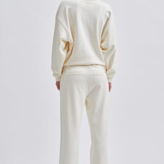 Straight leg cream joggers with side seam pockets and elasticated waistband with drawstring tie