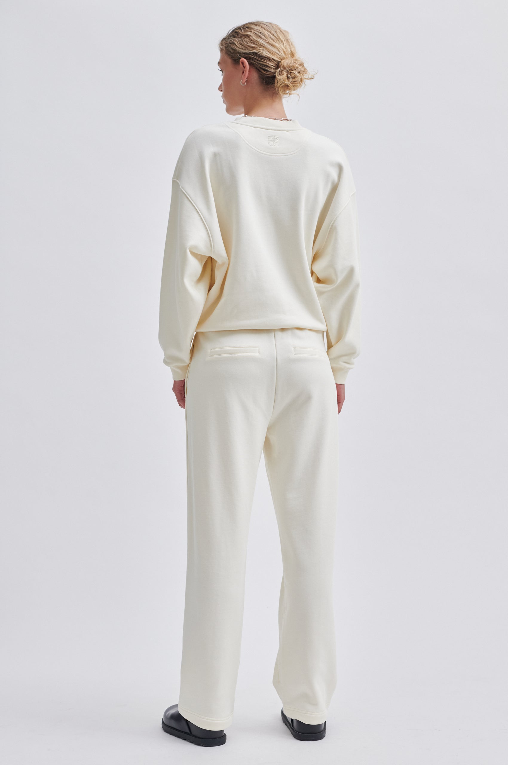 Straight leg cream joggers with side seam pockets and elasticated waistband with drawstring tie