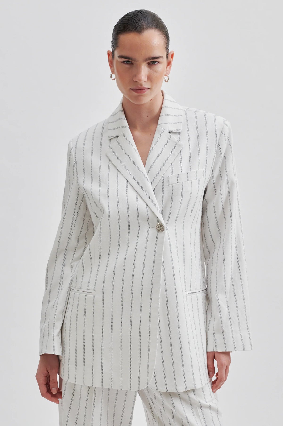 Off white single breasted blazer with generous overlap long sleeves and single silver button fastening with contrast stripe