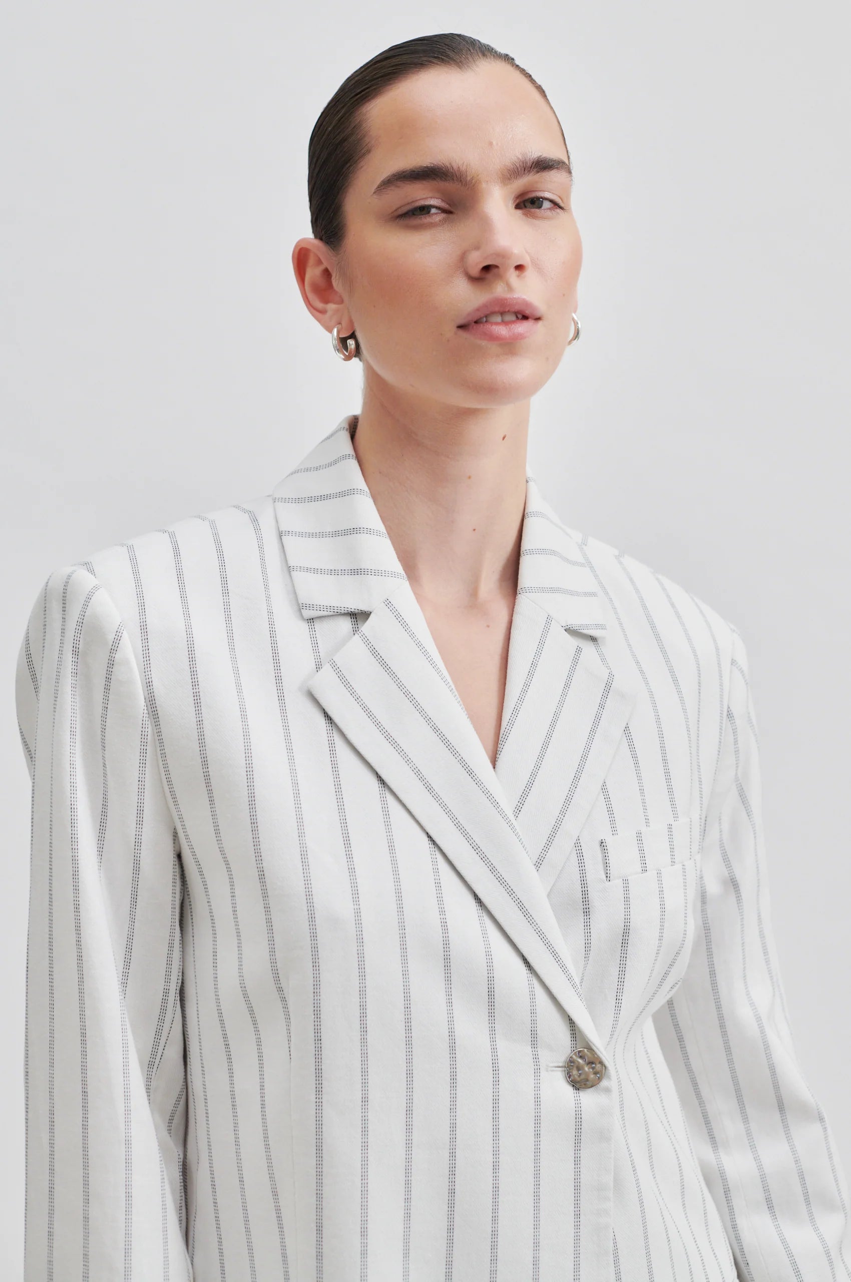 Off white single breasted blazer with generous overlap long sleeves and single silver button fastening with contrast stripe