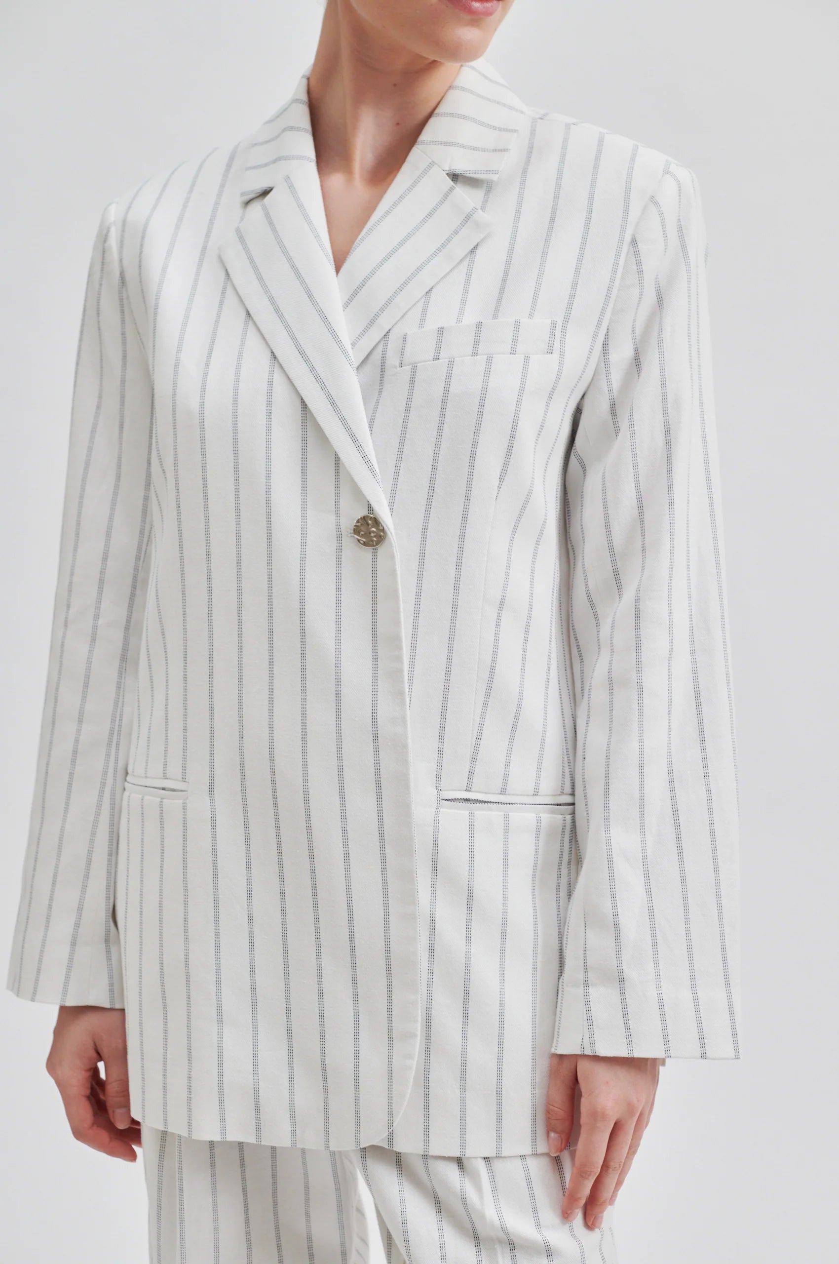 Off white single breasted blazer with generous overlap long sleeves and single silver button fastening with contrast stripe