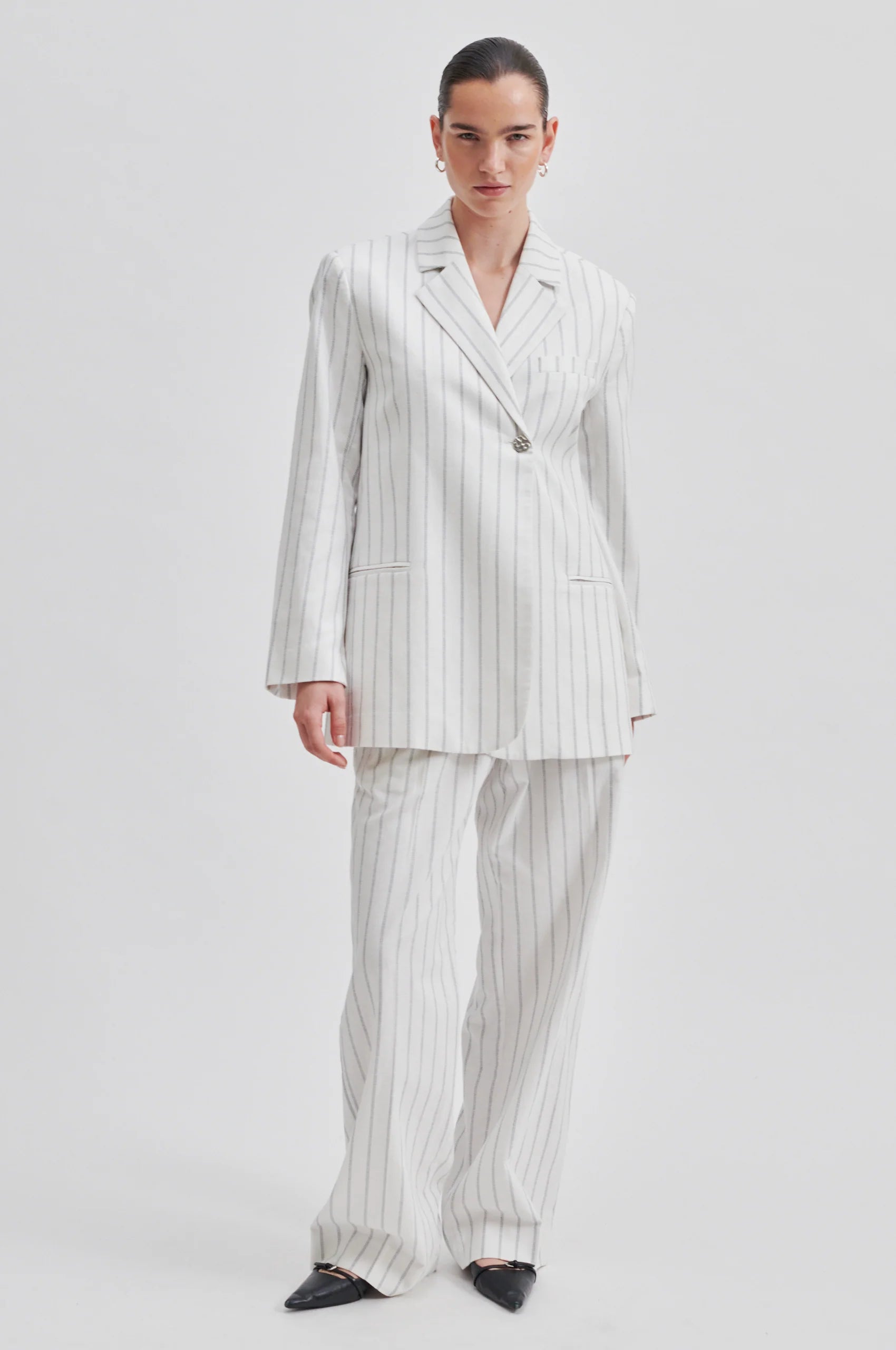 Off white single breasted blazer with generous overlap long sleeves and single silver button fastening with contrast stripe