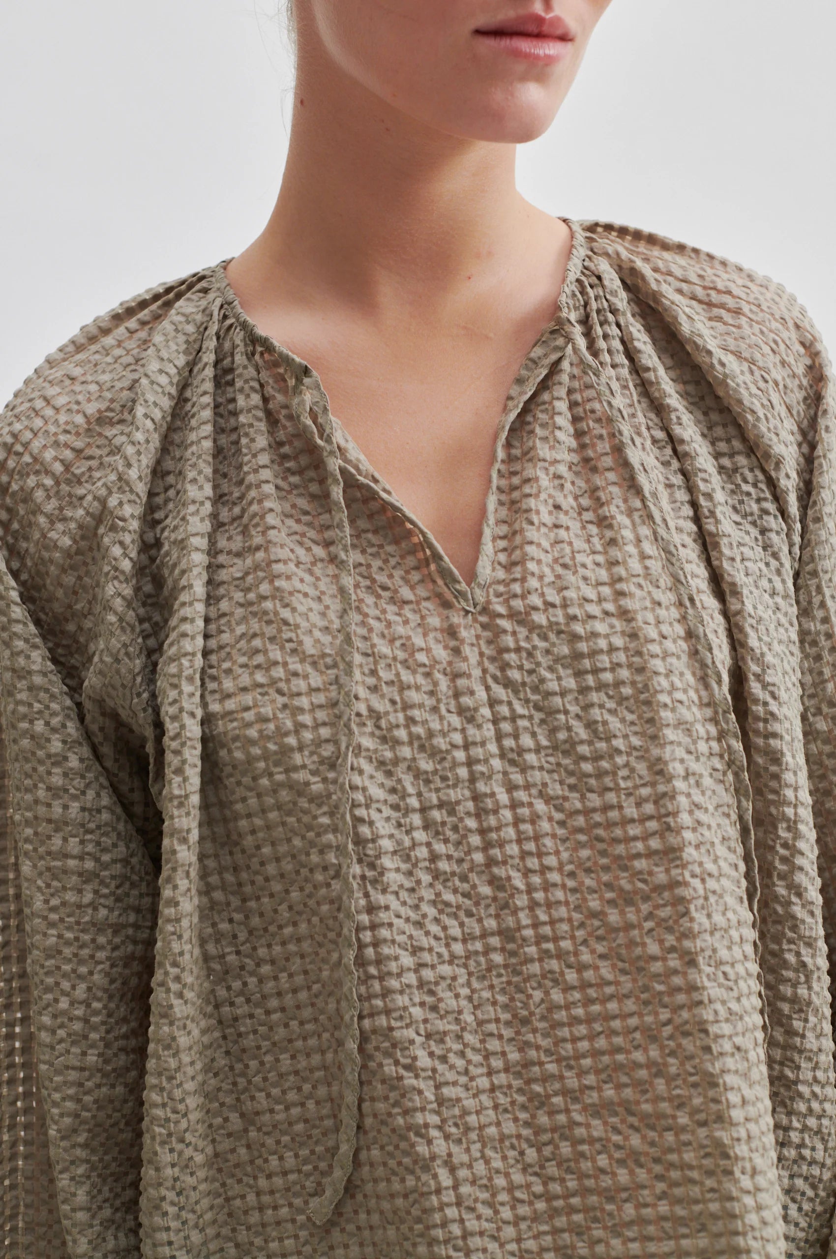 Notch neck beige seer sucker top with long raglan sleeves and elasticated cuffs