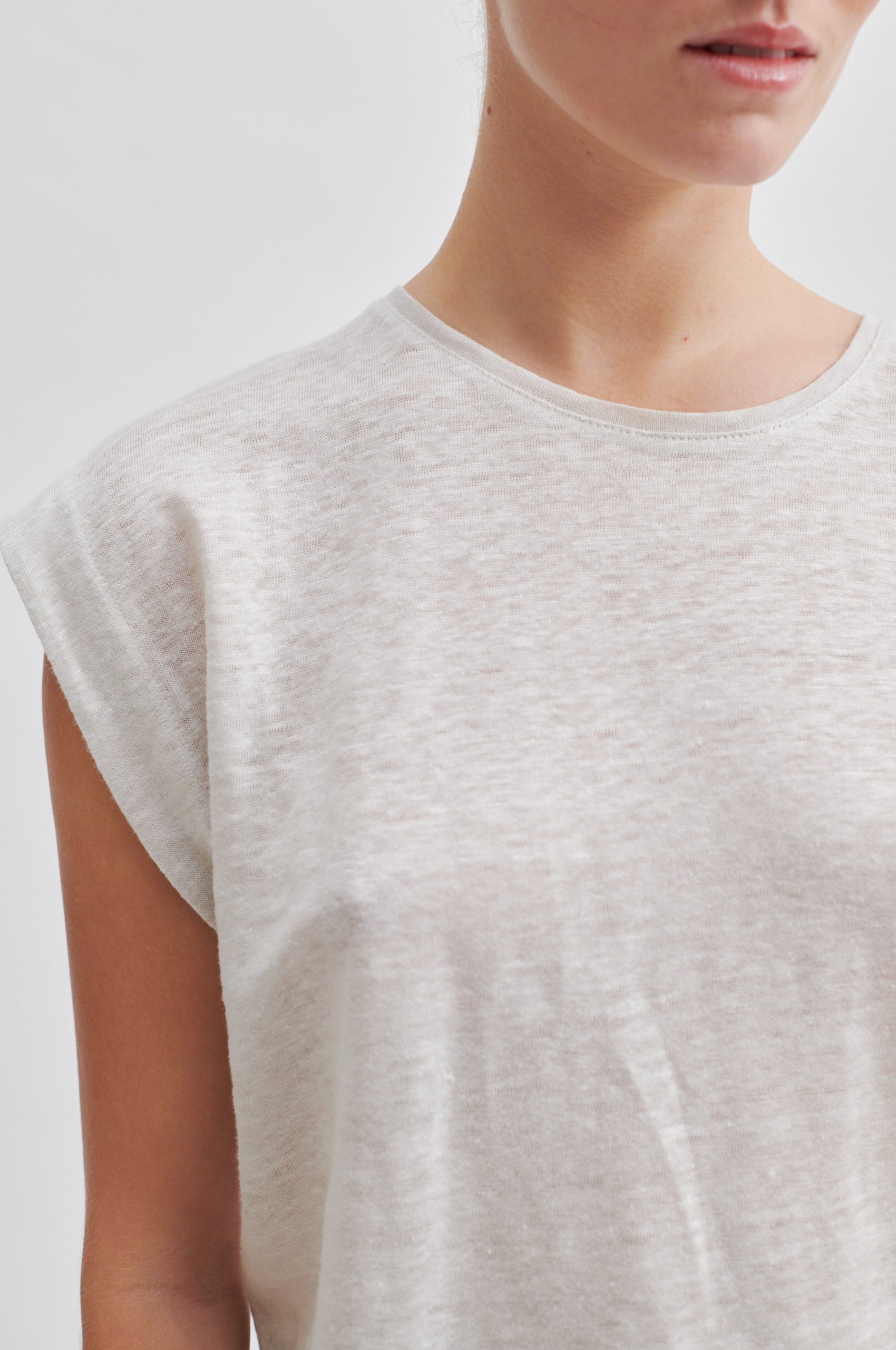 white t-shirt with deep arm holes and round neck close up