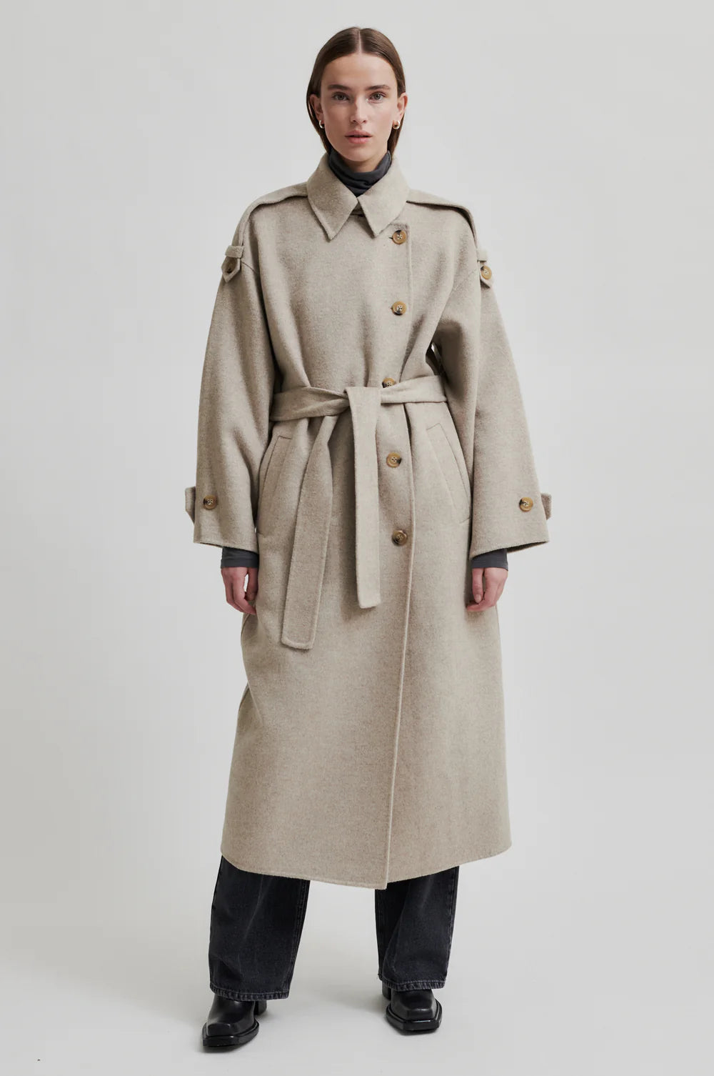 Beige wool double breasted coat with tie waist, asymmetric button fastening and side pockets model shot