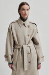 Beige wool double breasted coat with tie waist, asymmetric button fastening and side pockets close up