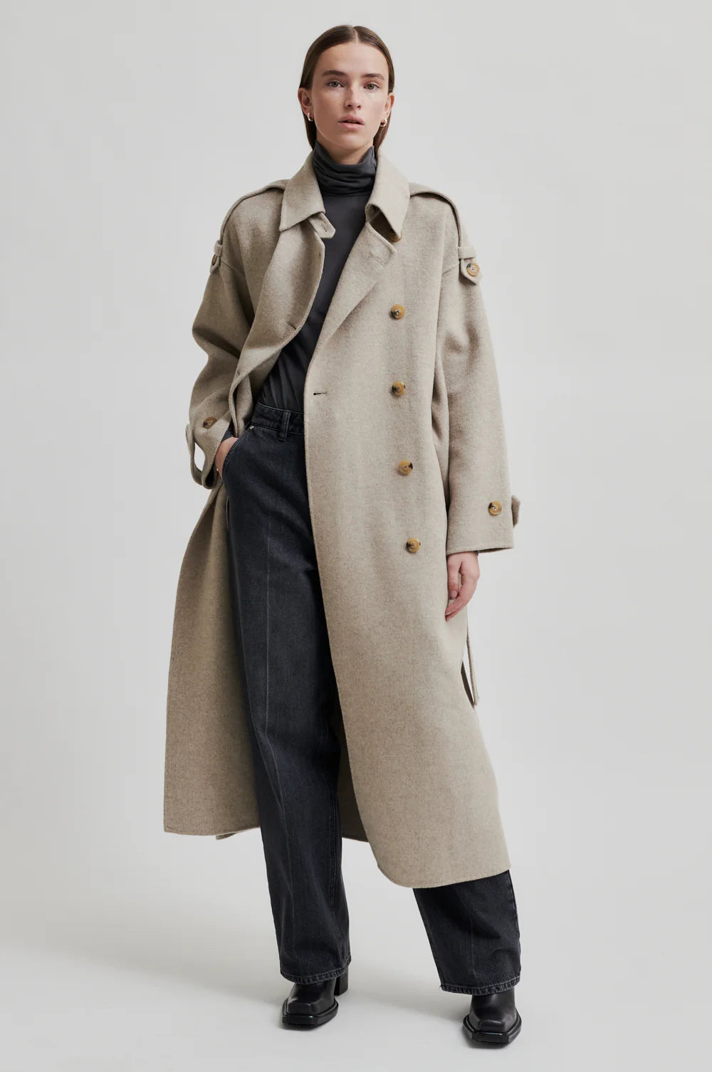 Beige wool double breasted coat with tie waist, asymmetric button fastening and side pockets model shot