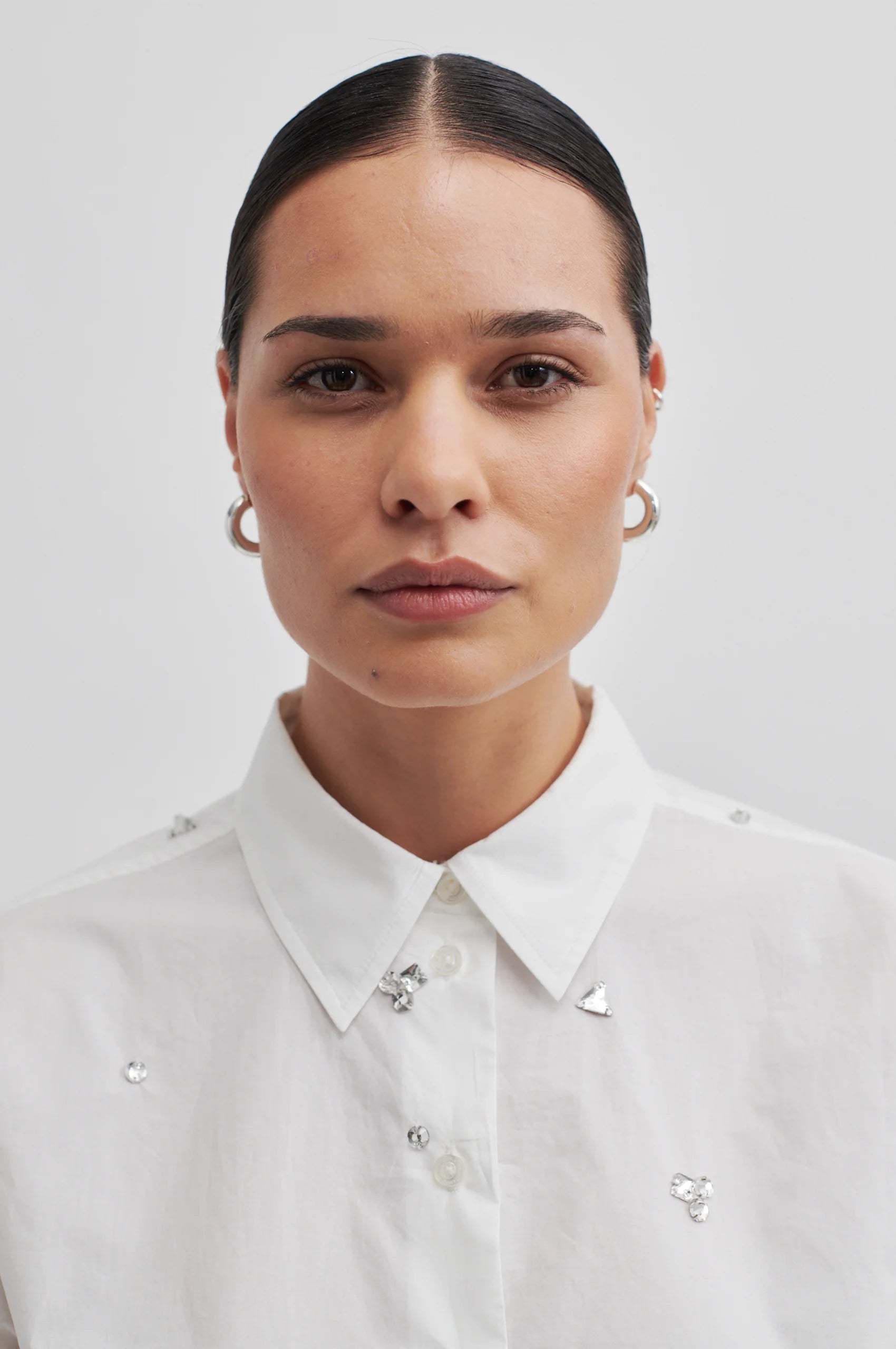 Cropped boxy white long sleeved shirt with scattered sewn on chunky gems