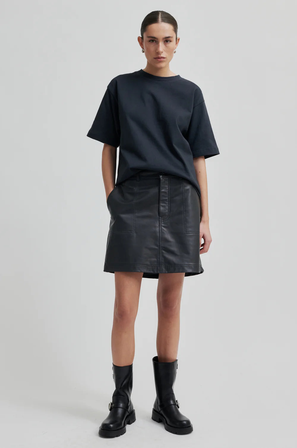 black leather short skirt with belt loops and button/zip fastening model shot