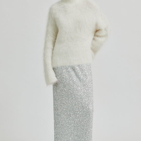 Cream knit on model with sequin skirt