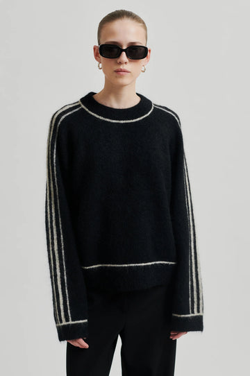 black round neck jumper with contrasting white stripes, long sleeves and ribbing