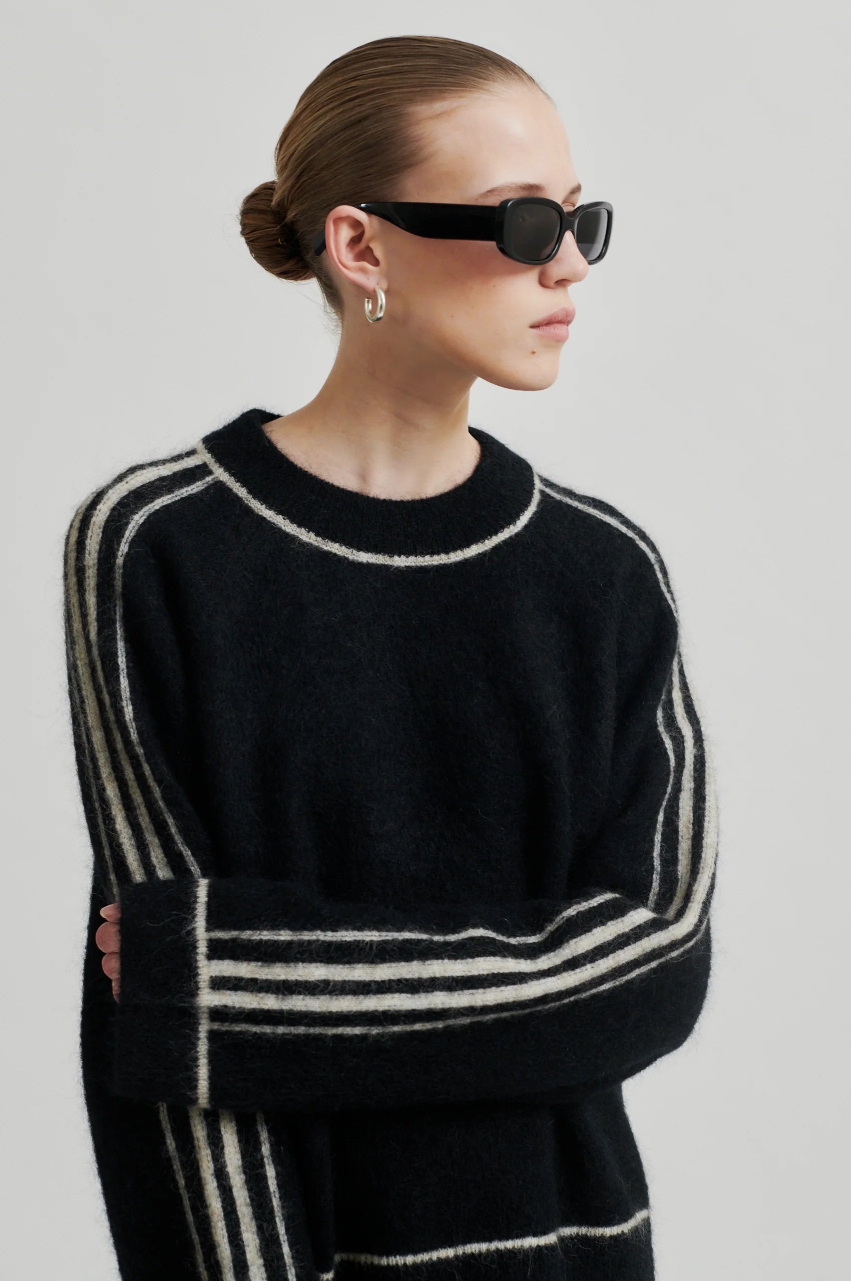 black round neck jumper with contrasting white stripes, long sleeves and ribbing