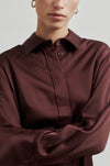 brown silky shirt with tie detail at the neck, concealed placket and buttoned cuffs close up