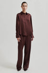 brown silky elasticated waist trousers with side pockets and rear welt pockets  model shot