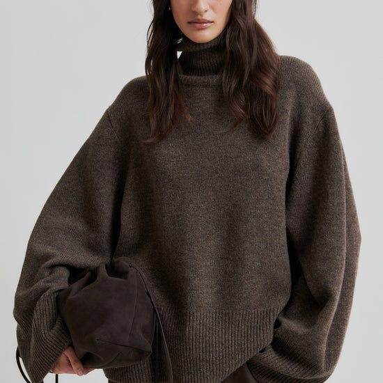 Person wearing a brown oversized sweater on a plain background from Second Female