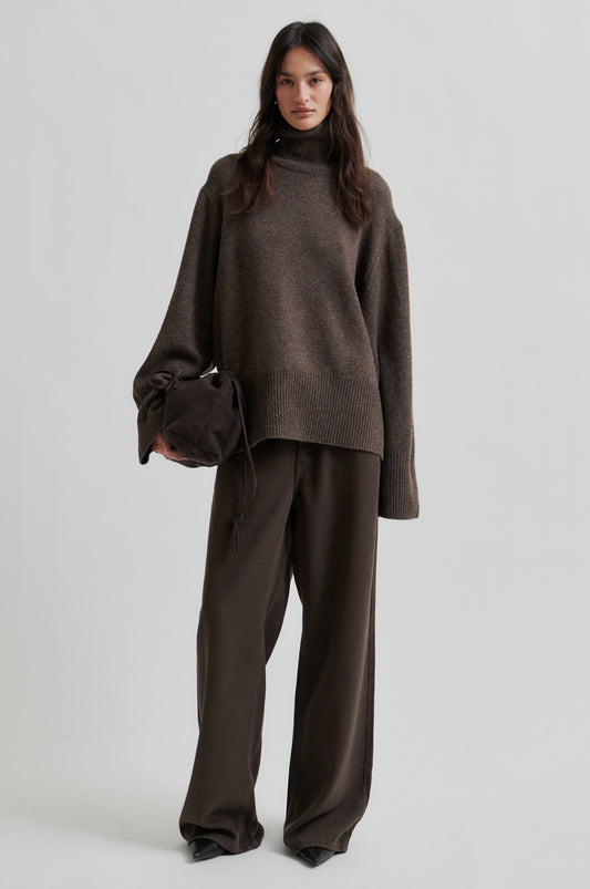 Woman wearing a brown outfit with a sweater and pants on a white background from Second Female