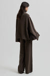 Person wearing a brown outfit with wide-leg pants on a light gray background from Second Female