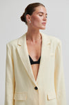 Woman wearing a light yellow blazer over a black top against a plain background from Second Female