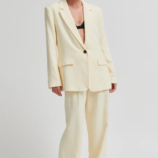 Woman wearing a light yellow suit on a white background from Second Female