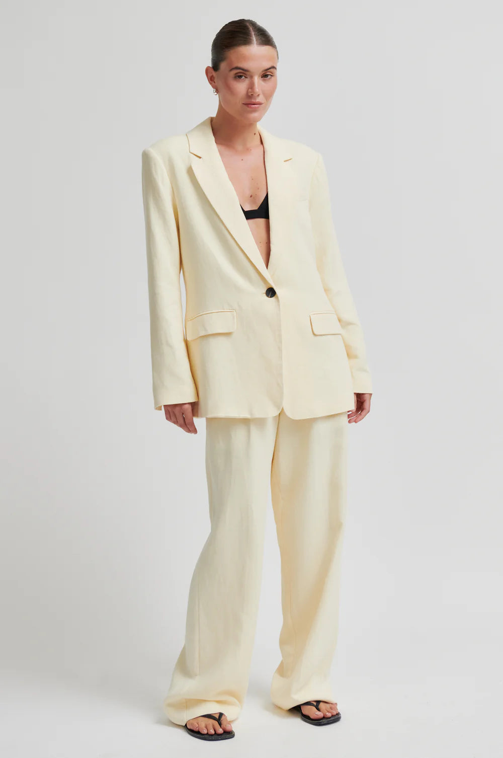 Woman wearing a light yellow suit on a white background from Second Female